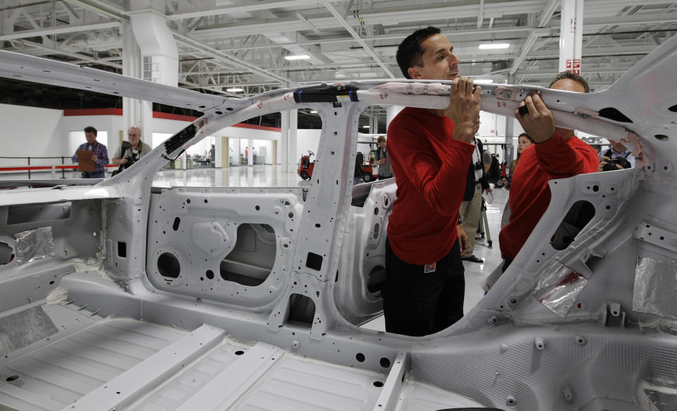 A worker inspects a Tesla Model S car at the Tesla factory in Fremont, Calif., Friday, June 22, 2012. The first Model S sedan car will be rolling off the assembly line on Friday. (AP Photo/Paul Sakuma)
