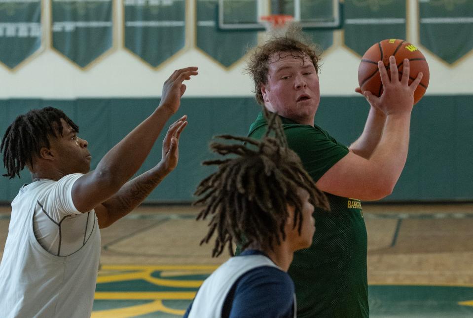 Red Bank Catholic's Tyler Burnham tries to pass in under basket as North's Micah Ford guards him. Toms River North Boys Basketball vs Red Bank Catholic in preseason scrimmage in Red Bank, NJ on December 9, 2023.