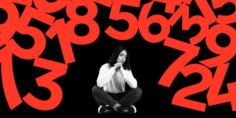 An anxious woman sitting on the floor as numbers are falling down
