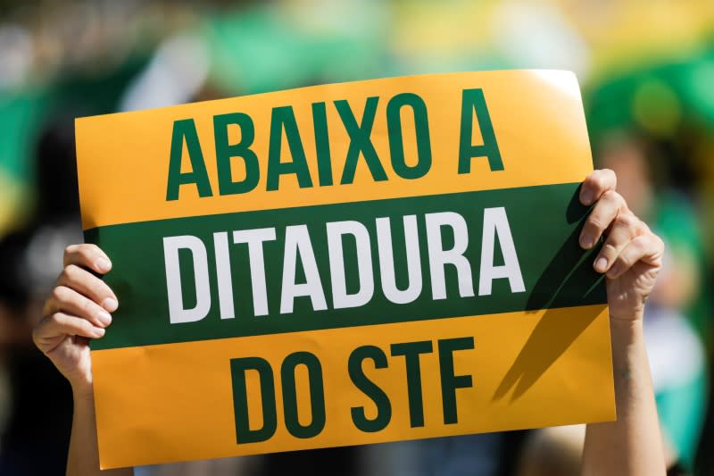 A supporter of Brazilian President Jair Bolsonaro displays a placard reading "Down with the Dictatorship of the Supreme Federal Court" during a protest, amid the coronavirus disease (COVID-19) outbreak, in Brasilia