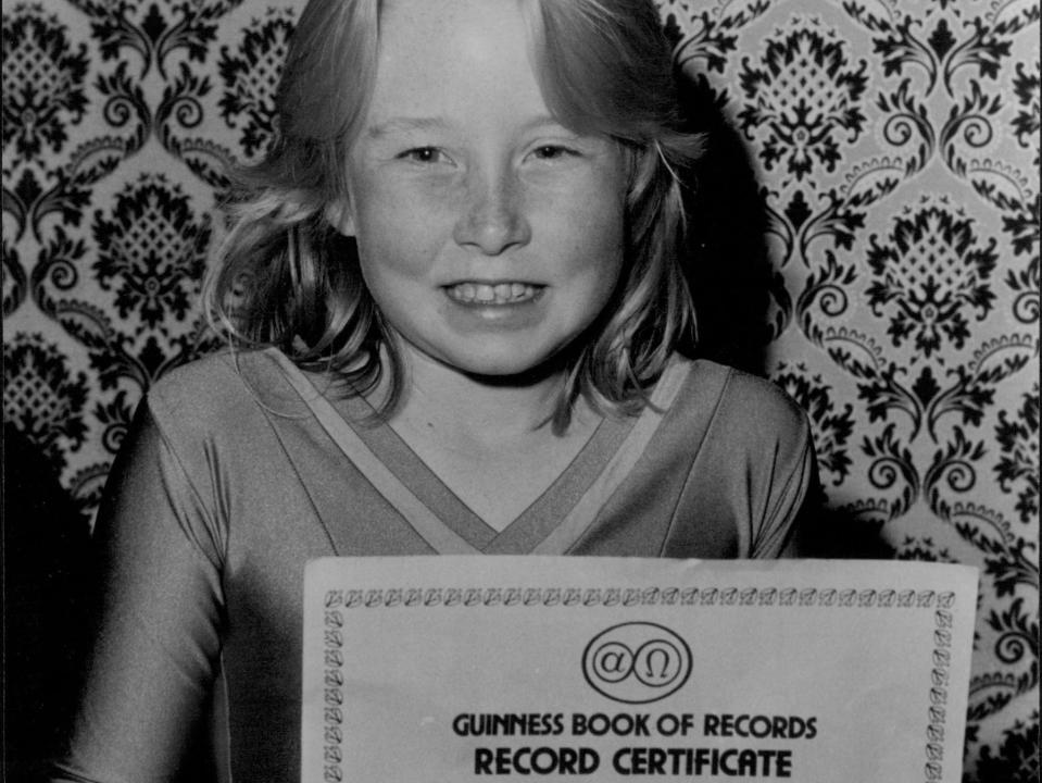 A girl with her GWR for lowest limbo roller-skater in 1975.