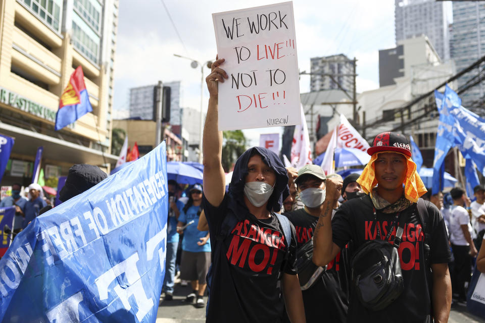 A man carries a poster during a protest to mark International Labor Day near the presidential palace in Manila, Philippines on Wednesday, May 1, 2024. Hundreds of Filipino workers from various labor groups took to the streets to mark Labor Day and demand a wage increase and job security amid soaring food and oil prices. (AP Photo/Basilio Sepe)