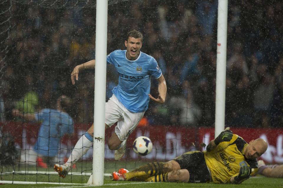Manchester City's Edin Dzeko, left, celebrates after scoring his first goal against Aston Villa during their English Premier League soccer match at the Etihad Stadium, in Manchester, England, Wednesday May 7, 2014. (AP Photo/Jon Super)