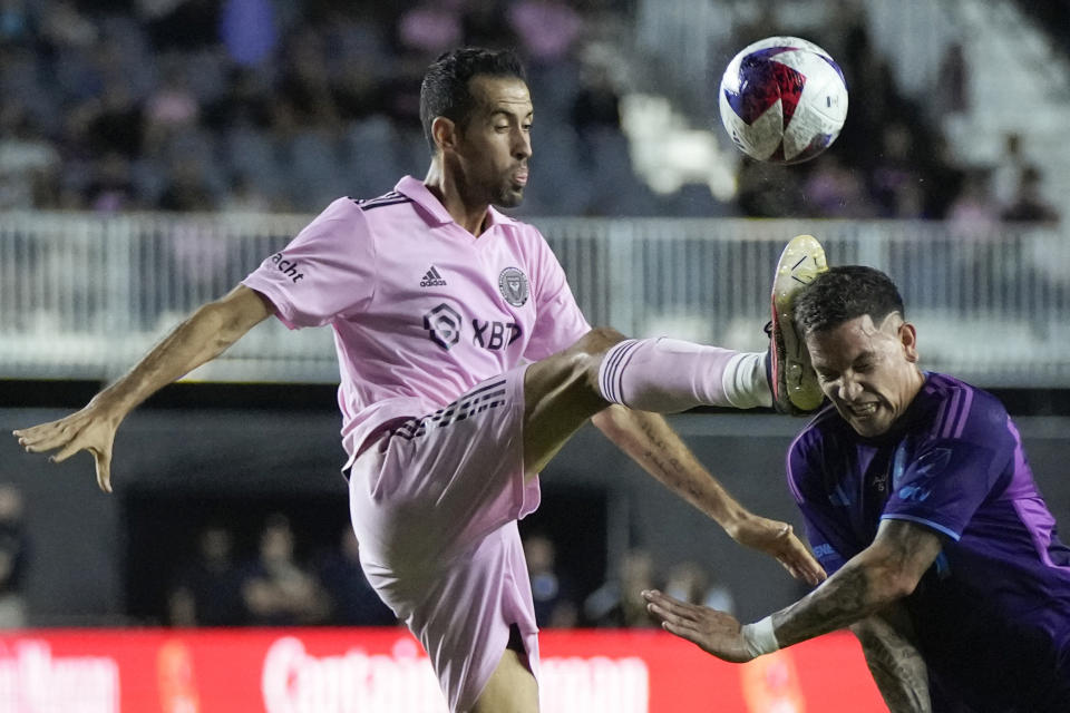Inter Miami midfielder Sergio Busquets (5) connects with the head of Charlotte FC forward Enzo Copetti (9) during the first half of an MLS soccer match, Wednesday, Oct. 18, 2023, in Fort Lauderdale, Fla. (AP Photo/Rebecca Blackwell)
