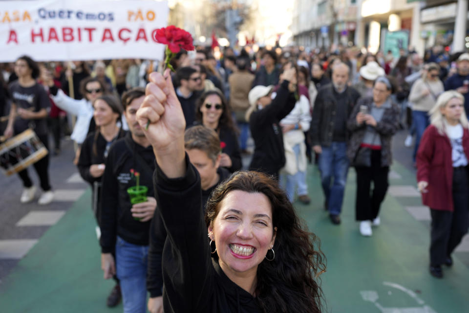 FILE - A woman holds up a red carnation, symbol of the Portuguese 1974 revolution that restored democracy in Portugal, during a protest against the country's housing crisis, in Lisbon, Portugal, Jan. 27, 2024. Corruption scandals have cast a shadow over Portugal's March 10 snap election. They have also fed public disenchantment with the country's political class as Portugal prepares to celebrate in April, 50 years of democracy, following the 1974 Carnation Revolution that toppled a rightist dictatorship. (AP Photo/Armando Franca, File)