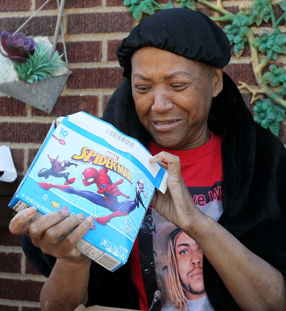 Rebecca Shepard looks through a Marvel snack box as she goes through items that belonged to her son who recently died. The packages with his belongings were delivered to the wrong address by FedEx.