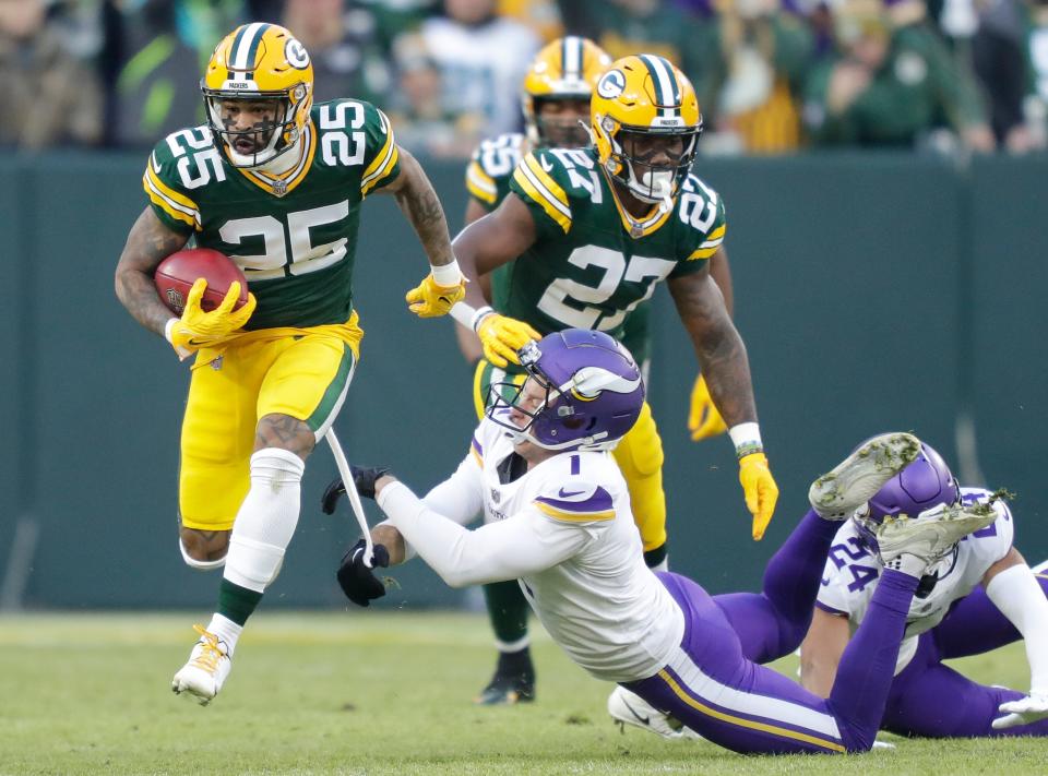 Green Bay Packers cornerback Keisean Nixon (25) runs back a kick off return for a touchdown against Minnesota Vikings place kicker Greg Joseph (1) during their football game Sunday, January 1, 2023, at Lambeau Field in Green Bay, Wis.