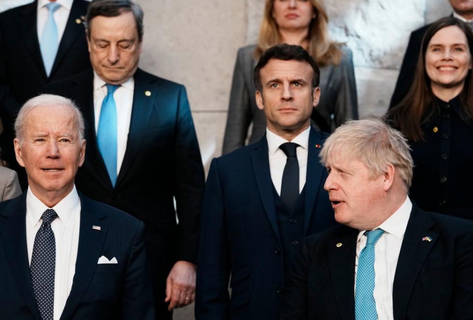 Boris Johnson, front right, looks toward US President Joe Biden, front left, at a group photo during an extraordinary Nato summit in Brussels (Thibault Camus/AP) (AP)