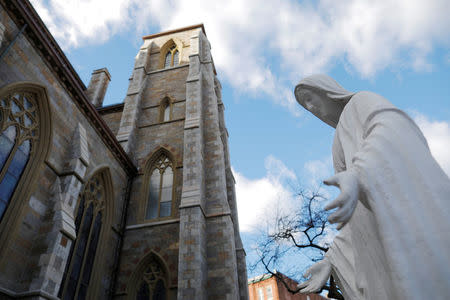 A statue of the Virgin Mary stands next to the Cathedral of the Holy Cross, where Cardinal Bernard Law, the former Archbishop of Boston who resigned in 2002 in disgrace after covering up years of sexual abuse of children, served in Boston, Massachusetts, U.S., December 20, 2017. REUTERS/Brian Snyder