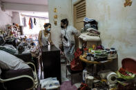 Keeping Hope Alive founder Fion Phuatalks, RIGHT, talks to a resident of a cluttered rental flat Sunday, Oct. 4, 2020 in Singapore. Members of the volunteer group conduct weekend door-to-door visits to deliver goods or provide services to people in need. (AP Photo/Ee Ming Toh)