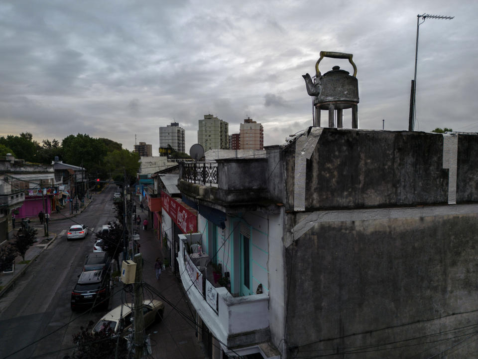 En la terraza de una casa de dos pisos se encuentra un gran tanque de agua en forma de tetera, como los que usan los argentinos para hacer una infusión conocida como mate, en el barrio de Villa Raffo de Buenos Aires, Argentina, el sábado 15 de octubre de 2022. (AP Foto/Rodrigo Abd)