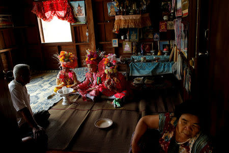 Danusorn Sdisaithaworn (L), 10, Gorsak Kong Tawan (C), 13, and Phuwadol Kong Tawan, 11, have lunch after praying in a house of a relative during an annual Poy Sang Long celebration, part of the traditional rite of passage for boys to be initiated as Buddhist novices, in Mae Hong Son, Thailand, April 4, 2018. REUTERS/Jorge Silva