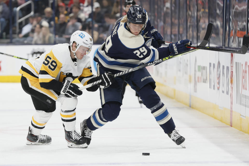 Pittsburgh Penguins' Jake Guentzel, left, hooks Columbus Blue Jackets' Patrik Laine during the second period of an NHL hockey game Sunday, Feb. 27, 2022, in Columbus, Ohio. Guentzel was penalized on the play. (AP Photo/Jay LaPrete)