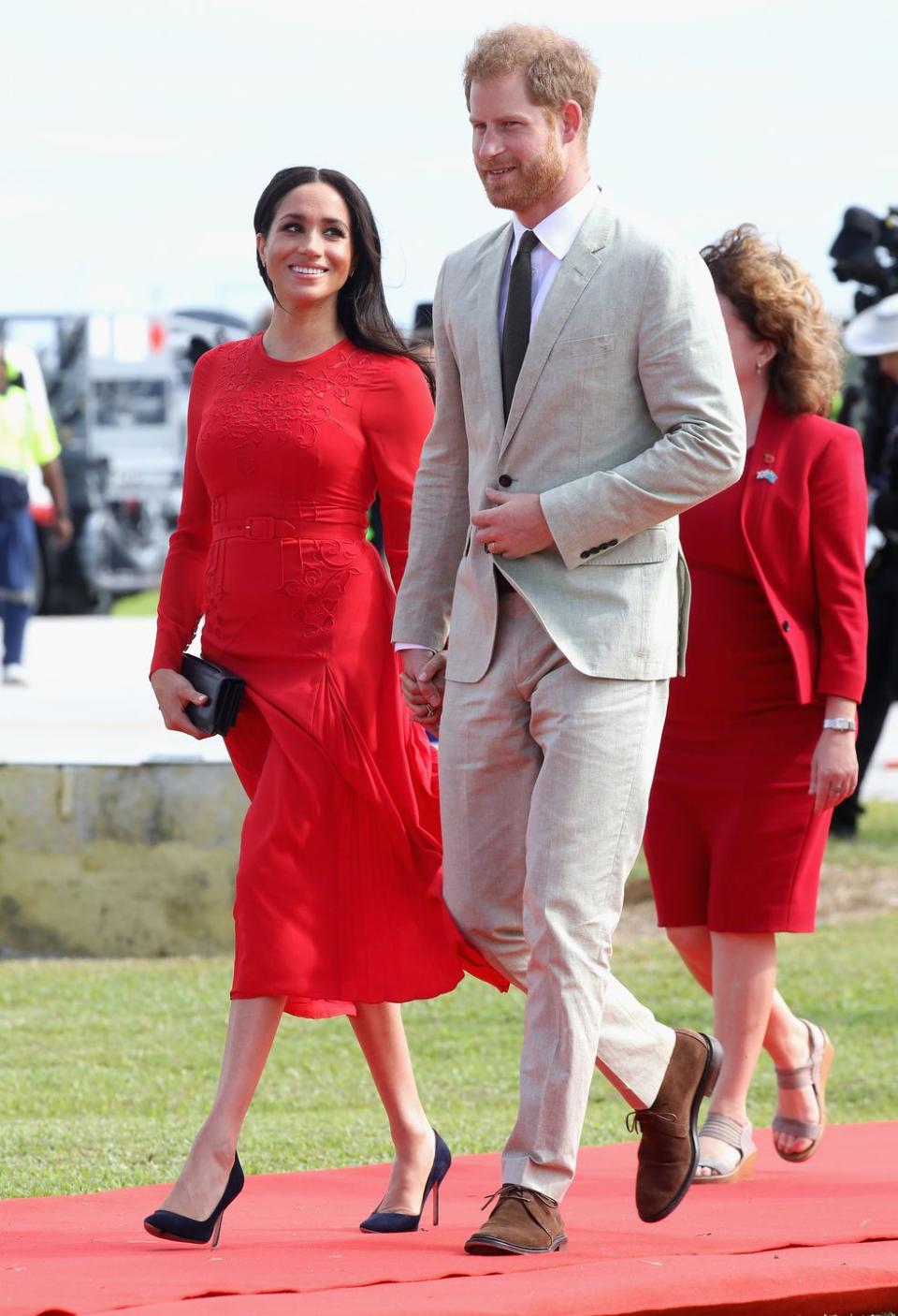 Meghan and Harry hold hands as they arrive in Tonga.