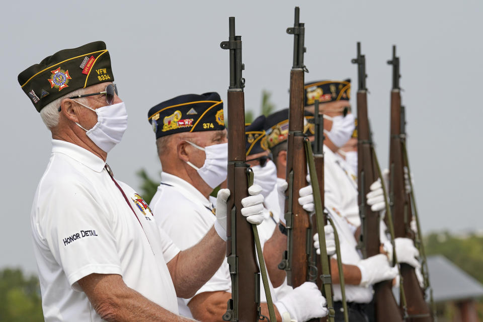 An honor guard with the American Legion Post 374 of Millard wear face masks against COVID-19 present arms during the graveside service of David Owen Cary at the Omaha National Cemetery in Omaha, Neb., Thursday, Sept. 17, 2020. (AP Photo/Nati Harnik)