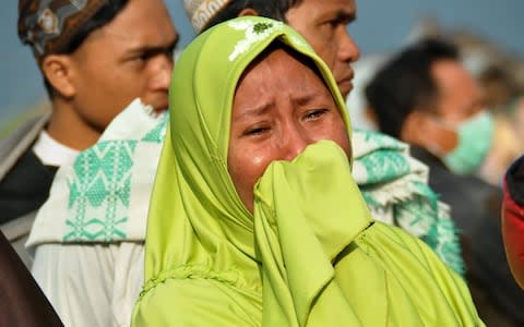 Grieving woman in aftermath of Indonesian earthquake and tsunami on Sulawesi island. - Credit: MUHAMMAD RIFKI/AFP/Getty