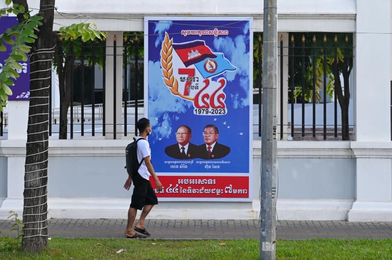 A pedestrian walks past a sign in front of the Cambodian People's Party headquarters in Phnom Penh ahead of the election. Photo by Thomas Maresca/UPI