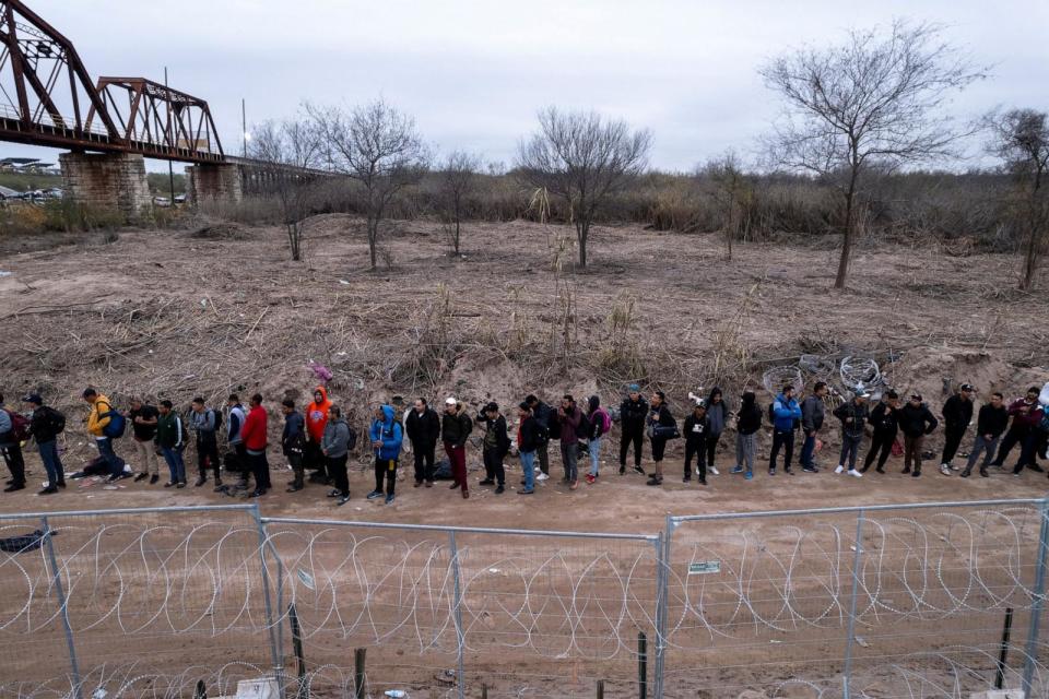 PHOTO: Migrants cross from Mexico into Eagle Pass, Texas (Cheney Orr/Reuters)