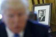 A photo of U.S. President Donald Trump's late father Fred Trump sits behind him as he gives an interview with Reuters in the Oval Office at the White House in Washington, U.S., February 23, 2017. REUTERS/Jonathan Ernst