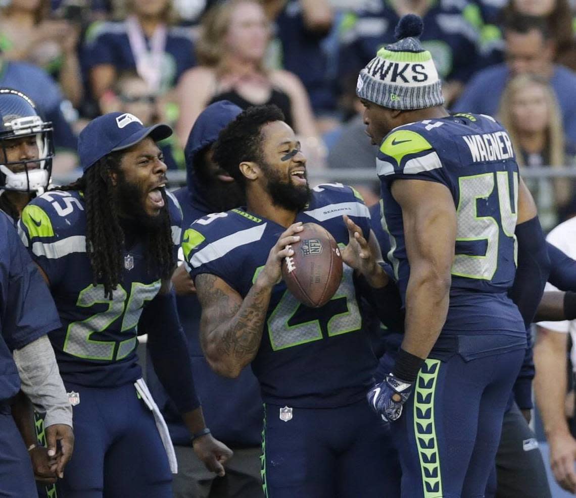 Seahawks’ All-Pro free safety Earl Thomas (29) and since-departed cornerback Richard Sherman (25) joke with All-Pro middle linebacker Bobby Wagner (54) during a preseason game last summer. Wagner told Seattle’s KJR-AM radio Monday he understands why Thomas may hold out into Seattle’s training camp that begins July 26. It’s because teams hold the advantage in player contracts, thus players need to get their money however and whenever they can.