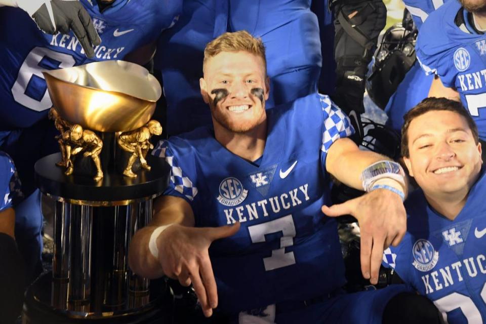 Will Levis celebrates with teammates and the Governor’s Cup following Kentucky’s win against Louisville last fall.