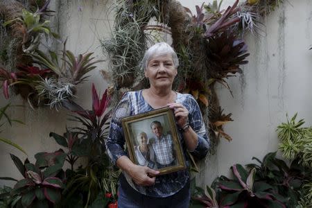 Josefa de Gonzalez poses for a picture while holding a portrait of herself and her late husband Rodolfo Gonzalez at her house in Caracas January 18, 2016. REUTERS/Marco Bello