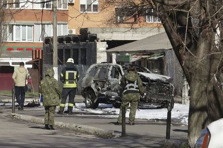 Members of the security and the emergency services work at the site of a car explosion, where Ukrainian state security service (SBU) officer Lieutenant Colonel Oleksandr Kharaberiush was killed, in the eastern port city of Mariupol, Ukraine March 31, 2017. REUTERS/Nikolai Ryabchenko