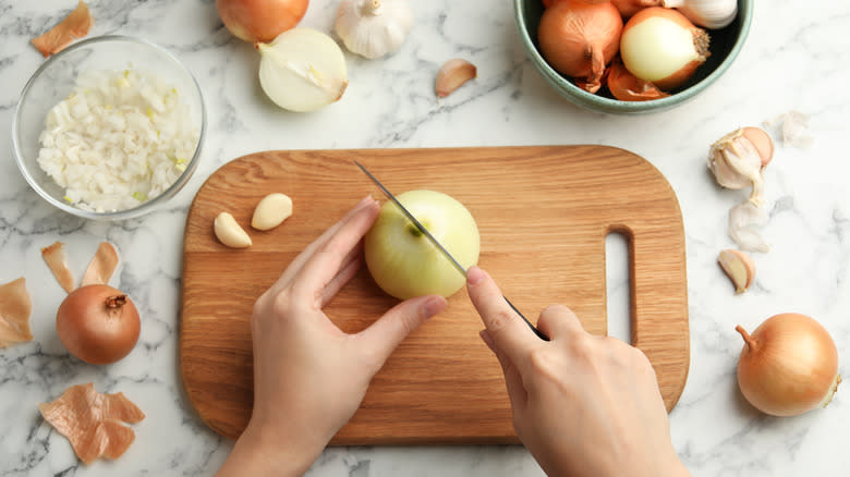 person cutting yellow onions