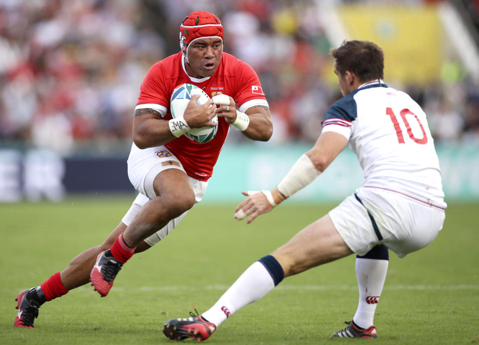 Tonga's Siale Piutau, left, runs at United States' AJ MacGinty during the Rugby World Cup Pool C game at Hanazono Rugby Stadium between USA and Tonga in Osaka, Japan, Sunday, Oct. 13, 2019. (Kyodo News via AP)