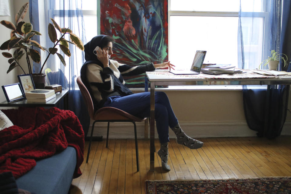 Iranian American activist Hoda Katebi, 24, speaks to another activist on Jan. 12, 2020 in her Chicago apartment. She and her network had received word that morning that an Iranian student was being detained at O'Hare International Airport. (AP Photo/Noreen Nasir)