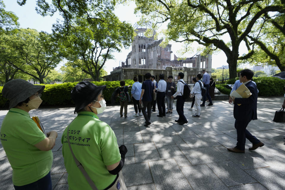 Volunteers talk to visitors at the famed Atomic Bomb Dome for its historical guidance, ahead of the Group of Seven nations' meetings in Hiroshima, western Japan, Wednesday, May 17, 2023. The Group of Seven nations' meetings start Friday. (AP Photo/Hiro Komae)