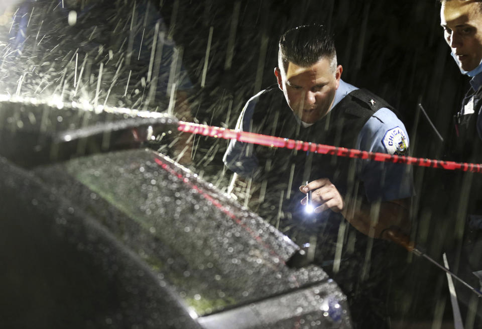 Police look at bullet holes on an SUV wherein a 3-year-old boy was fatally shot while riding in the vehicle with his father, outside West Suburban Medical Center Saturday, June 20, 2020, in Oak Park in Chicago. The boy was struck in the 5600 block of West Huron Street in the Austin neighborhood, and his father drove to the hospital, where he was pronounced dead. Multiple people, including several children, were killed as more than 100 people were shot in a wave of gunfire in Chicago over the Father’s Day weekend that produced the city’s highest number of shooting victims in a single weekend this year. (John J. Kim/Chicago Tribune via AP)