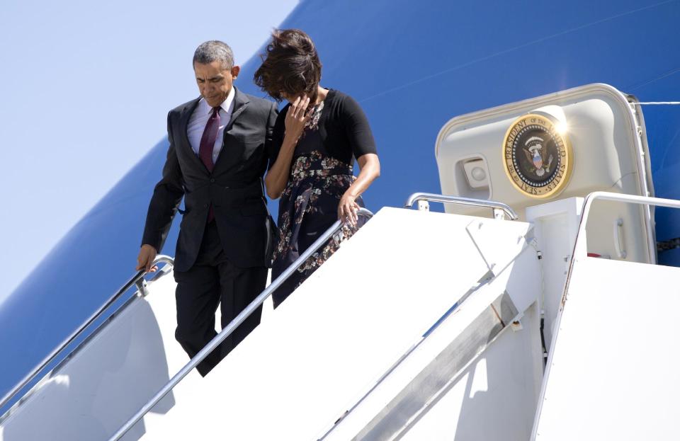 President Barack Obama and first lady Michelle Obama get off Air Force One upon their arrival at Robert Gray Army Air Field in Killeen, Texas, Wednesday, April 9, 2014, before traveling to Fort Hood for a memorial service for those killed there in a shooting last week. (AP Photo/Carolyn Kaster)