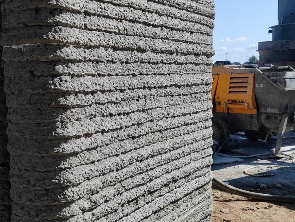 The walls of a 3D printed home among a construction site.
