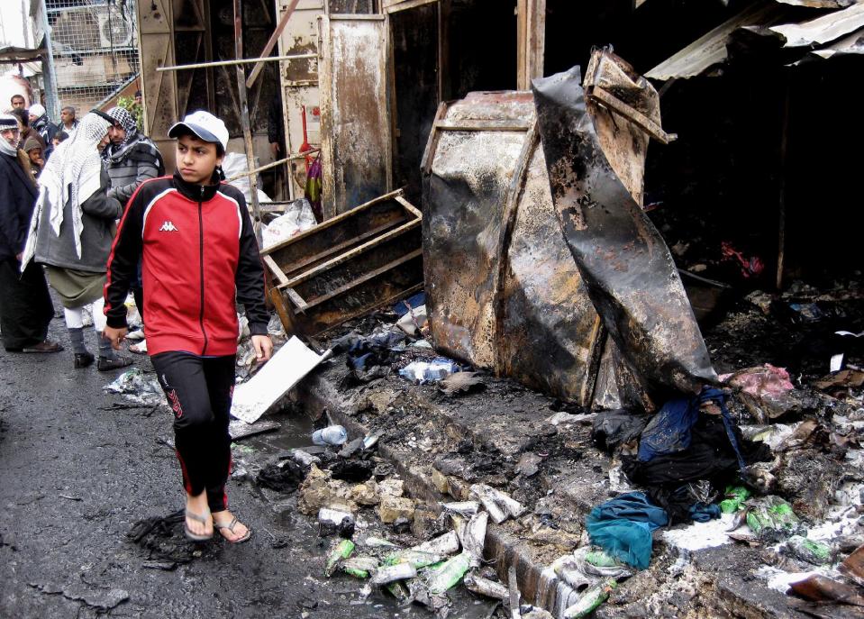 Civilians inspect the site of Monday's car bomb explosion at an outdoor market in Abu Disher neighborhood of southern Baghdad, Iraq, Tuesday, Feb. 4, 2014. Iraqi officials say car bombings on Monday in and near Baghdad have killed and wounded scores of people. (AP Photo/Khalid Mohammed)