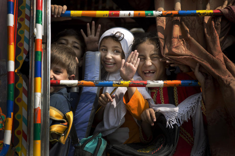 FILE - Children peek out of a bus as they leave school in Wajah Khiel, Swat Valley, Pakistan on Friday, Oct. 4, 2013. (AP Photo/Anja Niedringhaus, File)