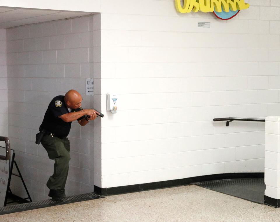 Savannah Chathah County Public Schools SRO Lt. Hector Eide takes cover behind a wall as he moves through the hall during an active shooter drill.