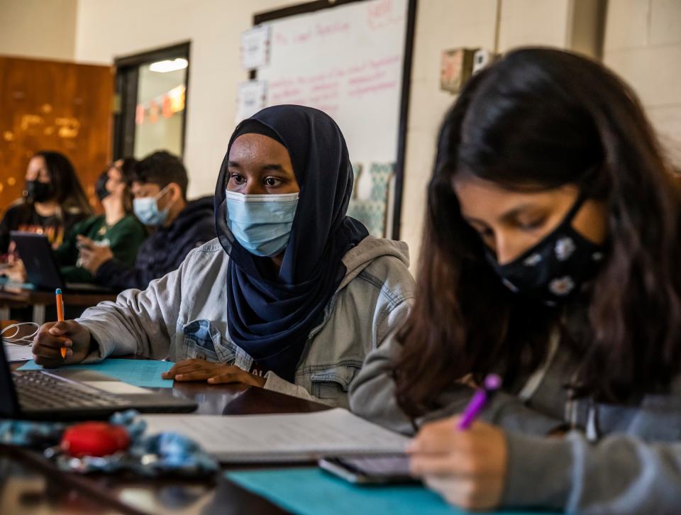 Nimo Hassen and Emely Hernandez Estrada work on a project Nov. 29, 2021, during their AP U.S. history class at Glencliff High School in Nashville, Tenn.