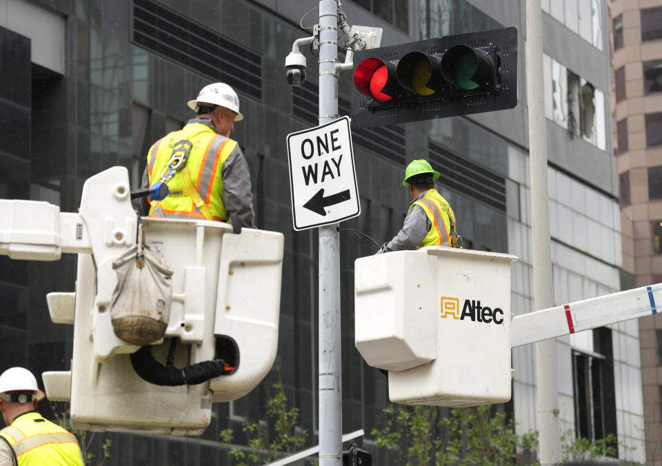 Workers repair a damaged street light downtown on Friday, May 17, 2024, in Houston, after a strong thunderstorm moved through Thursday evening. (Karen Warren/Houston Chronicle via AP)