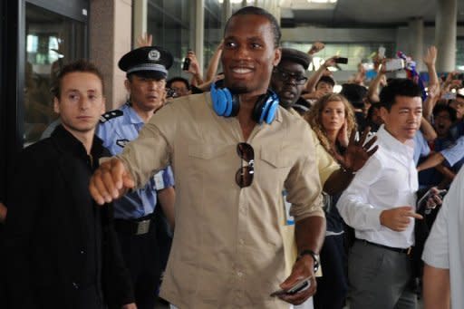 Ivory Coast striker Didier Drogba (C) exits Pudong international airport after arriving in Shanghai on July 14. Drogba was given a hero's welcome as he arrived in China Saturday to start a two-and-a-half year contract that is expected to make him one of football's highest-paid players