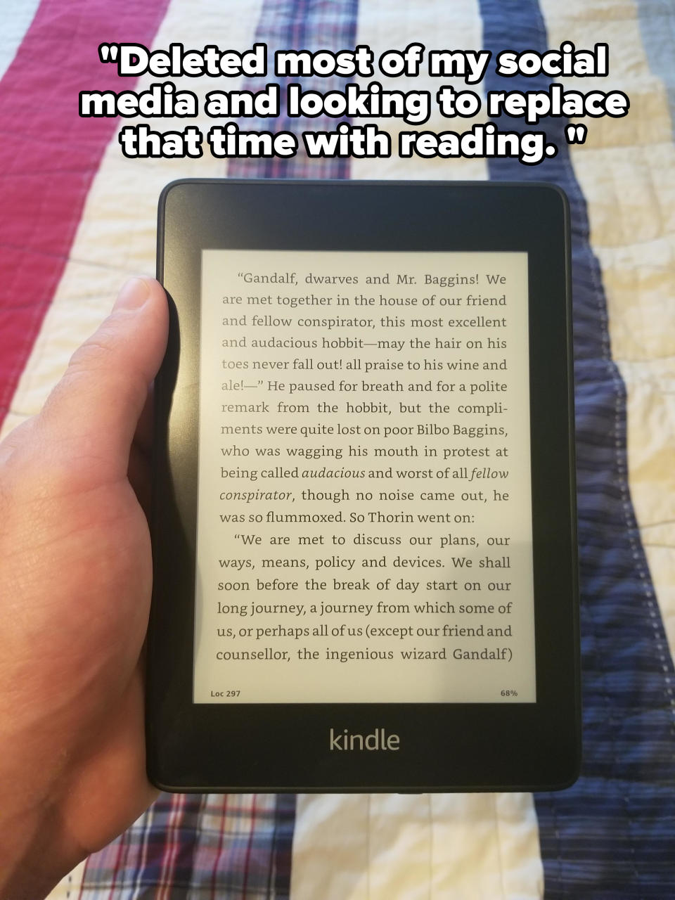 Hand holding a Kindle displaying a page from "The Lord of the Rings" with a text passage about Gandalf and Mr. Baggins