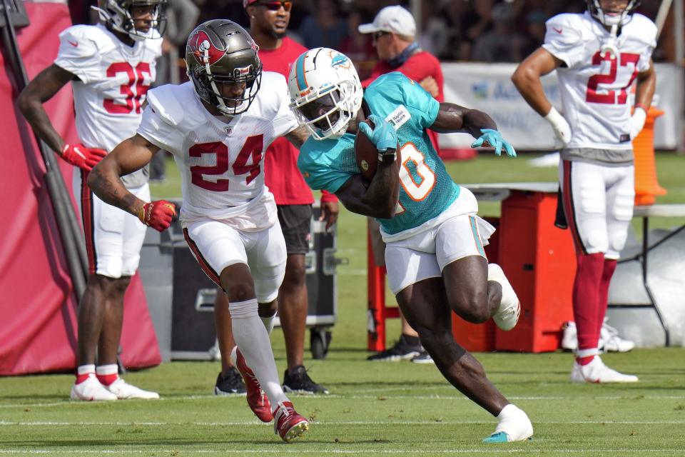 Dolphins receiver Tyreek Hill makes a catch in front of Bucs cornerback Carleton Davis III during Wednesday's joint practice in Tampa.