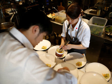 Chefs prepare dishes at HyLife Pork Table, a pork dish restaurant operated by Canadian pig farmer and pork processor HyLife, at Daikanyama district in Tokyo, Japan October 31, 2016. REUTERS/Issei Kato