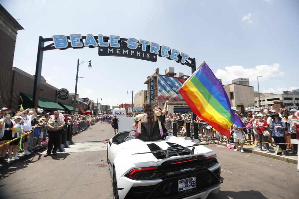 Participants in the parade ride in a car and wave a Pride flag during the Memphis Pride Parade on Saturday, June 3, 2023, on Beale Street in Memphis, Tenn.