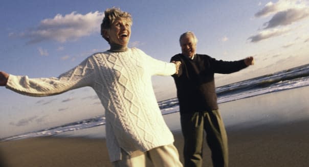 Senior couple holding hands on beach