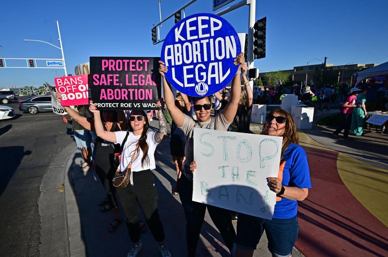 Abortion-rights supporters line up at a busy intersection in Scottsdale, Ariz. <a href="https://www.gettyimages.com/detail/news-photo/pro-abortion-rights-demonstrators-rally-in-scottsdale-news-photo/2147817471?adppopup=true" rel="nofollow noopener" target="_blank" data-ylk="slk:Frederic J. Brown/AFP via Getty Images;elm:context_link;itc:0;sec:content-canvas" class="link ">Frederic J. Brown/AFP via Getty Images</a>