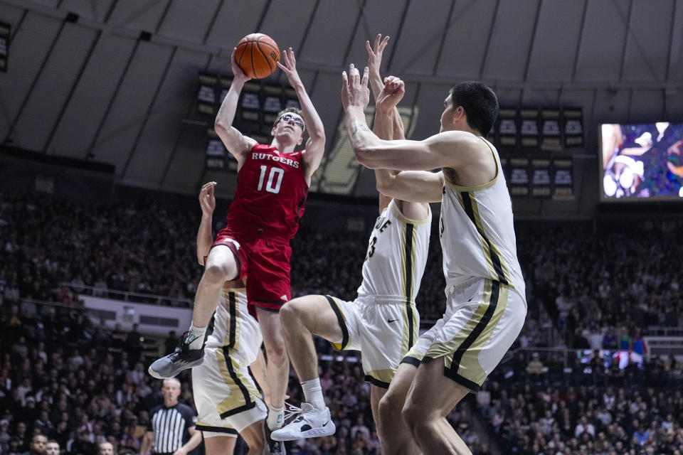 Rutgers guard Gavin Griffiths (10) shoots over Purdue forward Camden Heide, center, and center Zach Edey (15) during the first half of an NCAA college basketball game in West Lafayette, Ind., Thursday, Feb. 22, 2024. (AP Photo/Michael Conroy)