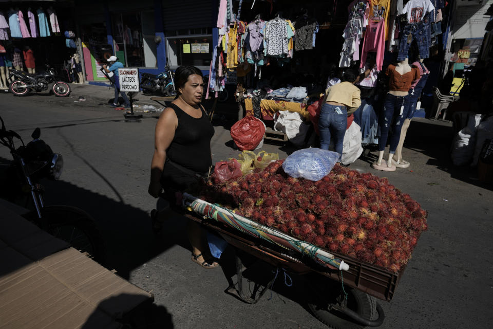 A fruit seller pushes her cart in the Comayaguela market on the outskirts of Tegucigalpa, days after general elections in Honduras, Tuesday, Nov. 30, 2021. Free Party presidential candidate Xiomara Castro, the wife of ousted former president Manuel Zelaya, has taken a commanding lead in Honduras' elections, capping a 12-year effort. (AP Photo/Moises Castillo)