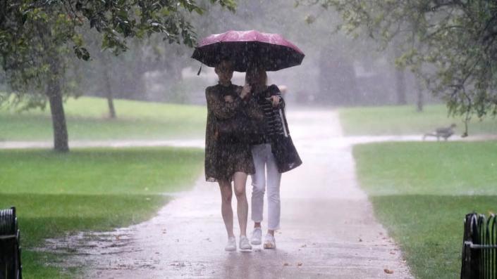 Dos mujeres caminando bajo la lluvia