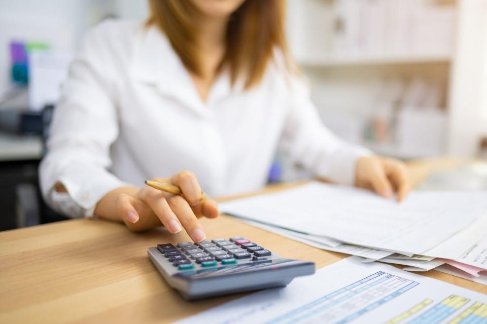 An image of a woman wit a calculator.